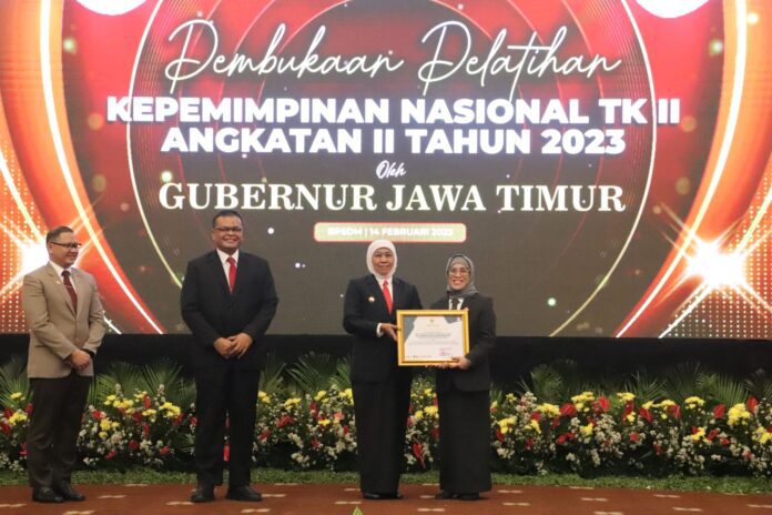 Gubernur Jawa Timur Khofifah Indar Parawansa saat menyerah penghargaan kepada Kepala Dinas DP3AK Jatim Restu Novi Widiani,