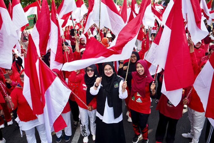 Bupati Banyuwangi Ipuk Fiestiandani membagikan bendera Merah Putih kepada ribuan warga saat ajang Community & Food Day (CFD) di sepanjang Jalan A. Yani 